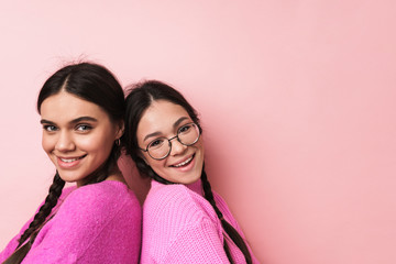 Wall Mural - Image of two happy teenage girls in casual clothes smiling at camera