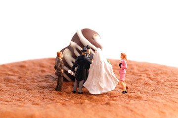 A macro photography and selecting focus of wedding ceremony miniature on cheesecake with Belgian Chocolate insight.