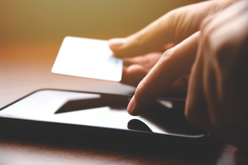 Poster - Closeup male hands holding credit card and using mobile smart phone for online shopping