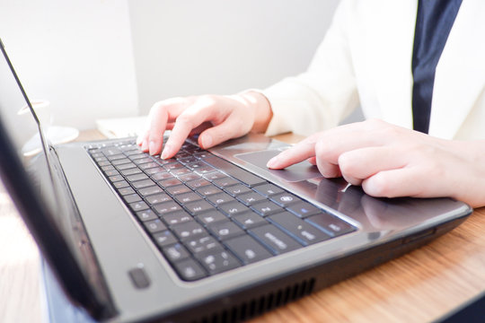 Cropped shot view of business woman’s hands typing the labtop with blank copy space screen for your information content or text message.