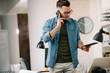 © JustLife - Businessman in office. Handsome man talking on phone at work.