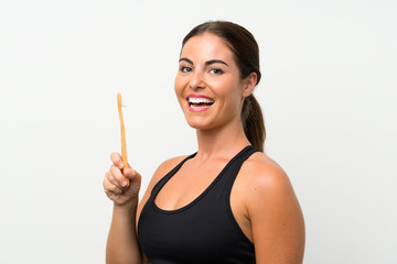 Wall Mural - Young woman over isolated white background brushing her teeth