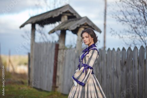 beautiful girl in a suit of the 19th century walks in the village Poster Mural XXL