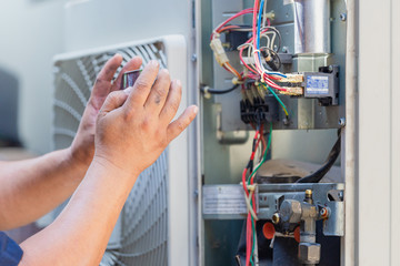 Selective focus of technician man hands using smartphone take a photo air conditioning system for attach in report