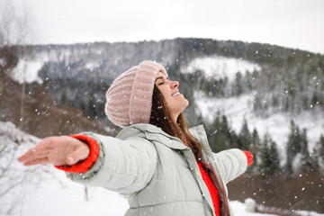 Canvas Print - Happy woman against snowy mountains. Winter vacation