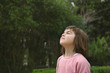 7 year old cute little girl of Asian appearance in the park breathes fresh air, ecology concept