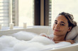 © PhotoAlto - Portrait of young woman relaxing while taking a bath in bathtub