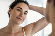 © PhotoAlto - Close-up of smiling beautiful young woman looking in mirror in bathroom