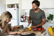© PhotoAlto - Happy young couple using digital tablet while cooking in kitchen