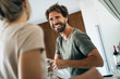© PhotoAlto - Smiling young couple cleaning plate in kitchen