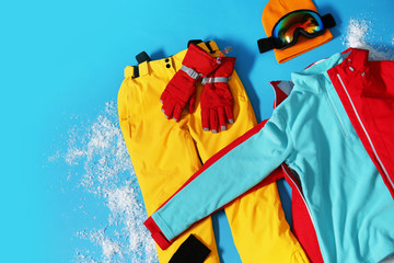 Poster - Stylish winter sport clothes on light blue background, flat lay