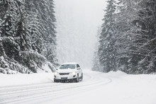 Modern Car On Snowy Road Near Forest. Winter Vacation