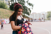 Teen Girl With Long Hair Looking For Something In Her Backpack