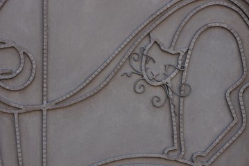 gray metal texture of iron wall with forged cat pattern