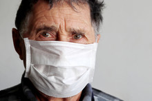 Elderly Man In Medical Mask Looks Upset. Concept Of Coronavirus Protection, Illness, Fever, Cold And Flu