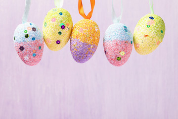 Wall Mural - Hanging Easter eggs decorated in various colors. Festive background with copy space