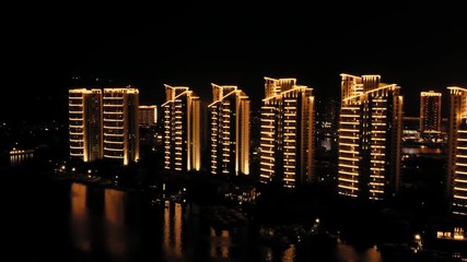 Poster - aerial view on the city at night light buildings at the riverbank