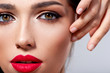 © Valua Vitaly - Beautiful young fashion woman with red lipstick.  Brunette woman with a clean skin of face. Portrait of model with bright red lips. Glamour fashion model with bright gloss make-up  posing at studio.