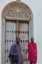 Two Masai Men Standing In Front Of A Traditional Door In Old Town
