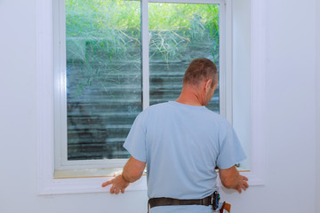 Wall Mural - Worker installing trim around a window