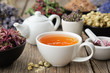 Healthy herbal tea cup. Teapot and  medicinal herbs on table. Herbal medicine.