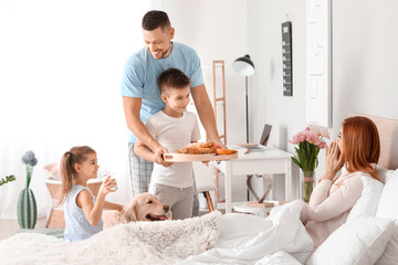 Wall Mural - Happy husband with children bringing his wife breakfast in bed