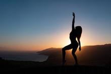 Silhouette Of Woman Enjoying Freedom Feeling Happy At Sunset With Mountains And Sea On Background