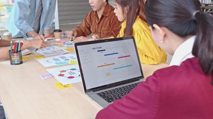 Young Asian business creative team work together, mobile application software design project. Brainstorm meeting, internet technology, office coworker teamwork concept. 4K tilt up backward dolly shot