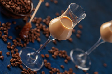 Wall Mural - Irish cream or Coffee Liqueur and coffee beans on blue background