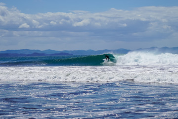 Beautiful aerial view of surfers surfing in Naranjo Beach 