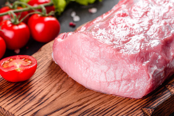 Fresh pieces pork ready to cook on a dark background in the kitchen