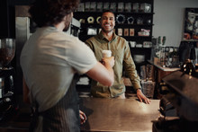 Cheerful Customer Buying Takeaway Coffee From Modern Cafe House Standing Across Counter