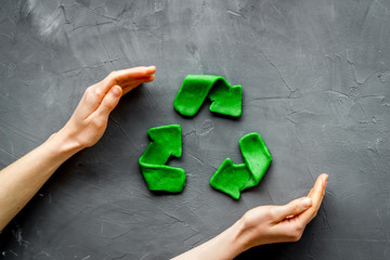 Wall Mural - Recycling symbol - composition with hands - on grey background top-down copy space