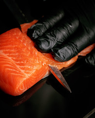 Wall Mural - chef slices the salmon steak. the process of making sushi rolls. Traditional Japanese cuisine