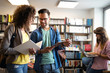 © NDABCREATIVITY - Group of college students studying in the school library
