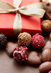 Wall Mural - sweets concept - close up of handmade chocolate candies and red gift box