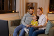 © Syda Productions - family, leisure and people concept - happy smiling father, mother and little daughter watching tv at home at night