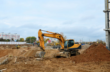 Wall Mural - Wheel excavator working at a construction site during laying or replacement of underground storm sewer pipes. Backhoe dig the ground for the foundation, laying storm sewer pipes.