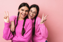 Image Of Two Happy Teenage Girls Smiling And Gesturing Peace Fingers