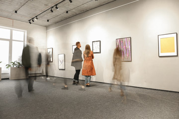 Exhibition in modern crowded art gallery