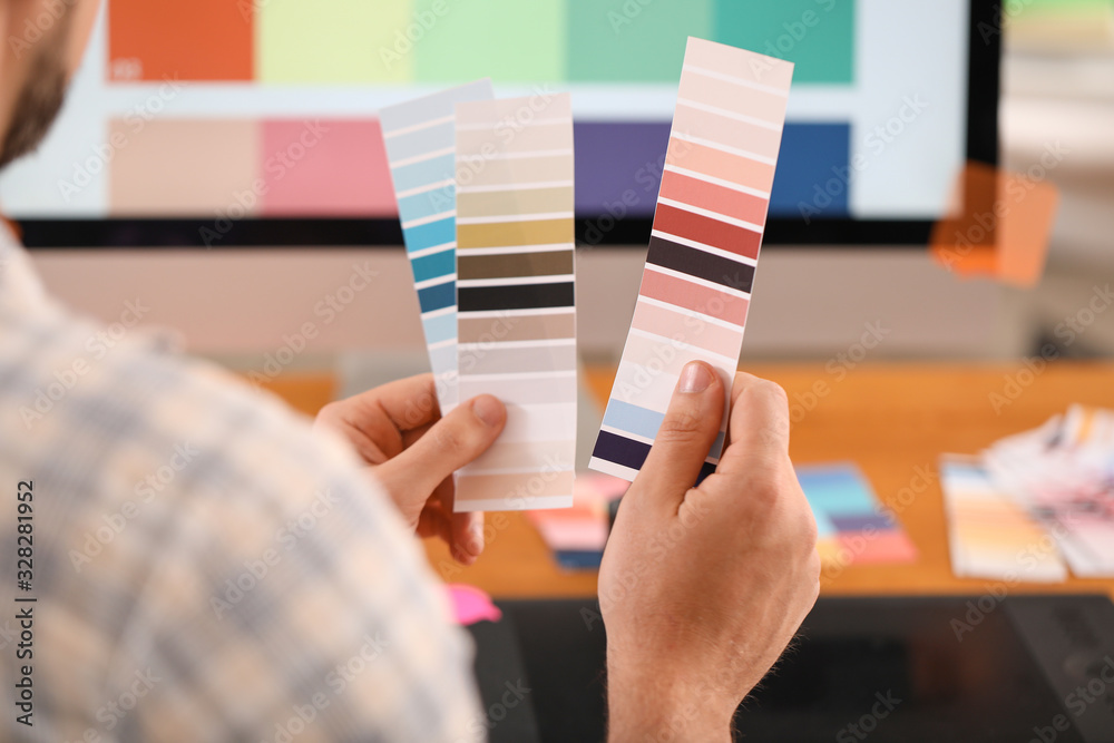 Male designer with color palettes in office, closeup