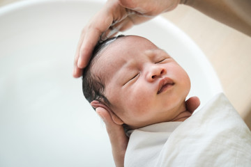 Mother is washing baby hair. Mom cleaning her baby hair.