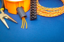Kit Spare Parts And Tools, Orange Wires For Electrical Prepared Before Repair Or Setting On Blue Background