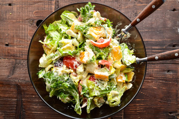 Wall Mural - Vegetable spring-summer salad in a plate. Top view. Healthy food, bell pepper, avocado, dressing, tomatoes. Vegetarianism and veganism. Healthy lunch. Horizontal view.