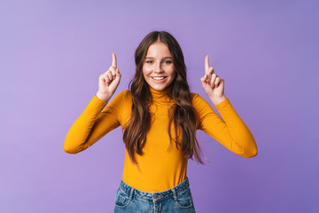 Wall Mural - Image of young beautiful woman smiling and pointing fingers at copyspace