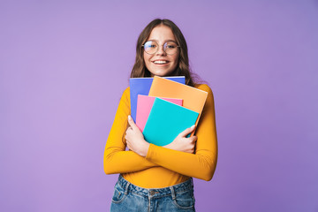 image of young beautiful student girl smiling and holding exercise books