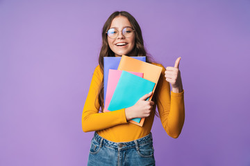 Wall Mural - Image of young beautiful student girl smiling and holding exercise books