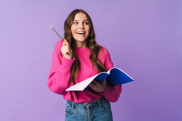 Image of young beautiful student girl smiling and holding exercise book