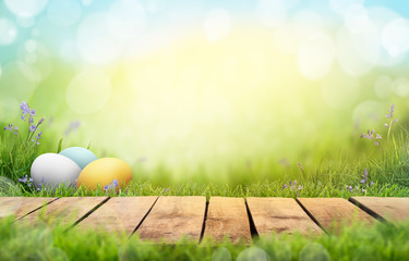 A wooden product display top with an Easter background of painted eggs and green grass and meadows.