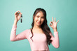 Cute asian girl showing car key.